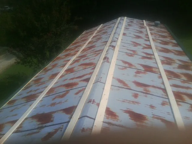 Rusted metal roof panels with new wood purlins before replacement — Storm Damage Roof Repair in Bon Aqua by Roofing Brothers