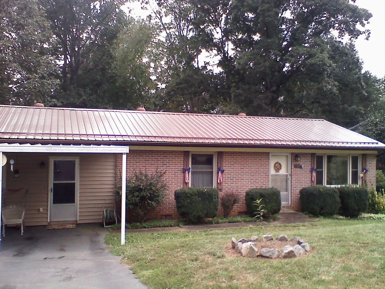 Bronze metal roof and carport on a brick ranch home — Roof Repair work by our crew in Bon Aqua